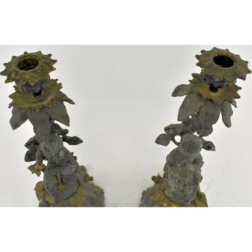 173 - A pair of early 20th century spelter & bronze figurative mantel candlesticks. Each candlestick havin... 