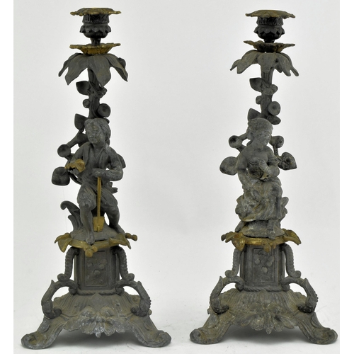 173 - A pair of early 20th century spelter & bronze figurative mantel candlesticks. Each candlestick havin... 