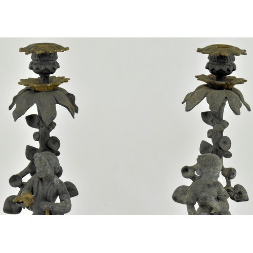 173 - A pair of early 20th century spelter & bronze figurative mantel candlesticks. Each candlestick havin... 