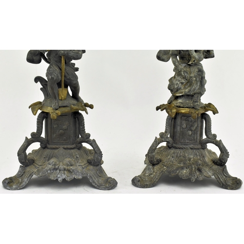 173 - A pair of early 20th century spelter & bronze figurative mantel candlesticks. Each candlestick havin... 