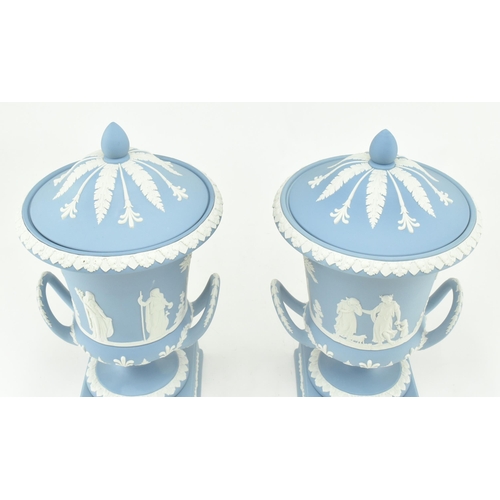 208 - A pair of Wedgwood jasperware ceramic light blue twin handled campagna urns vases with lids. Each va... 