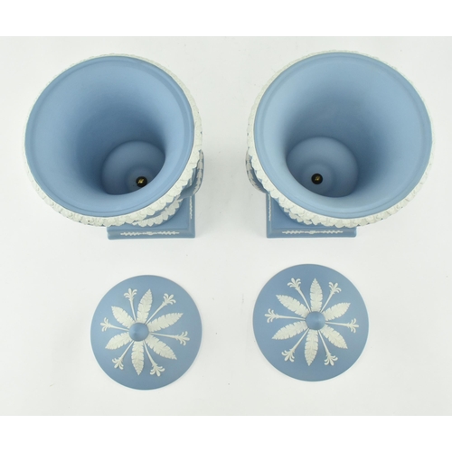 208 - A pair of Wedgwood jasperware ceramic light blue twin handled campagna urns vases with lids. Each va... 