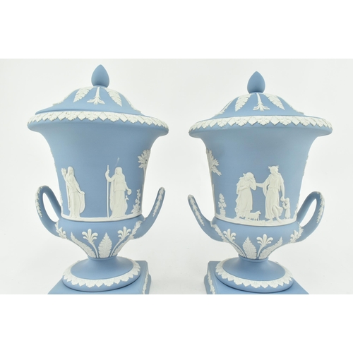 208 - A pair of Wedgwood jasperware ceramic light blue twin handled campagna urns vases with lids. Each va... 