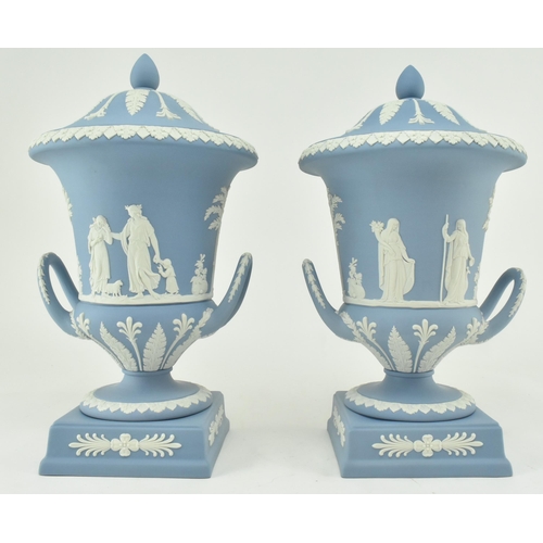 208 - A pair of Wedgwood jasperware ceramic light blue twin handled campagna urns vases with lids. Each va... 