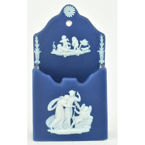 212 - A Wedgwood dark blue jasperware rectangular wall pocket, decorated with three classical maidens, the... 