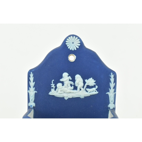 212 - A Wedgwood dark blue jasperware rectangular wall pocket, decorated with three classical maidens, the... 