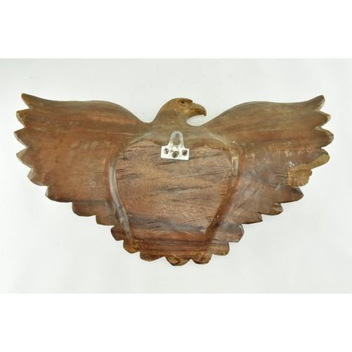 218 - An early 20th century circa 1930s carved wood wall hanging eagle sculpture. The figure depicting a s... 