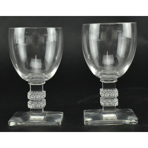 23 - A set of five Lalique Argos clear glass table glasses. Each with a stepped square column with moulde... 