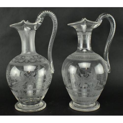 30 - A pair of mid 19th century Victorian Stourbridge style engraved claret glass ewers. Each ewer engrav... 