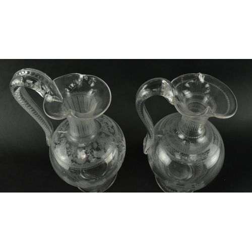 30 - A pair of mid 19th century Victorian Stourbridge style engraved claret glass ewers. Each ewer engrav... 