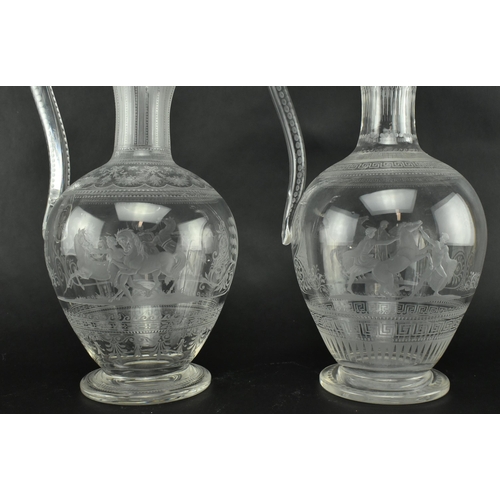 30 - A pair of mid 19th century Victorian Stourbridge style engraved claret glass ewers. Each ewer engrav... 