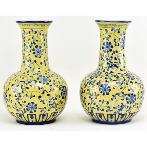 45 - A pair of Chinese Qianlong marked ceramic yellow blue and white glazed vases. Each vase having a fla... 