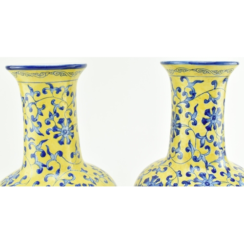 45 - A pair of Chinese Qianlong marked ceramic yellow blue and white glazed vases. Each vase having a fla... 