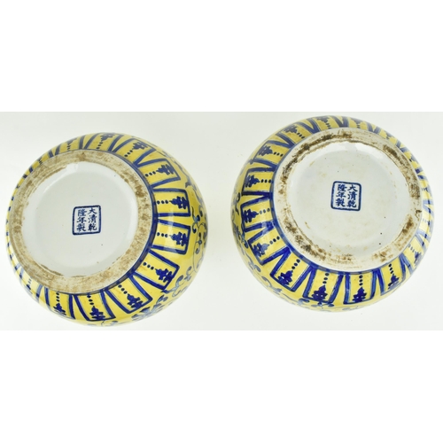 45 - A pair of Chinese Qianlong marked ceramic yellow blue and white glazed vases. Each vase having a fla... 