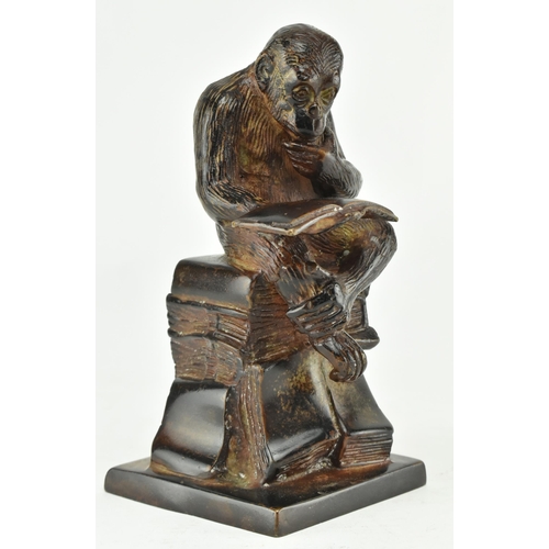 52 - A bronze figure depicting Darwin's reading monkey. The sculpture featuring a monkey reading a book i... 