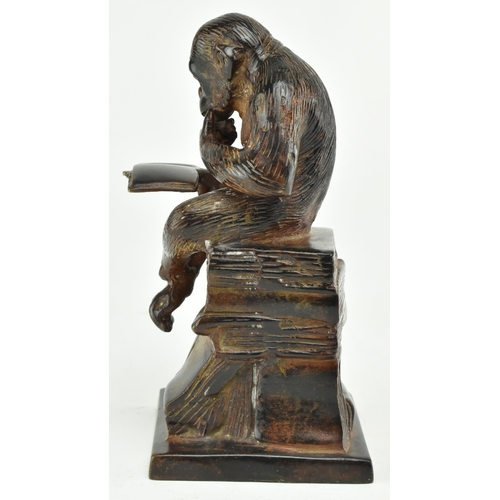 52 - A bronze figure depicting Darwin's reading monkey. The sculpture featuring a monkey reading a book i... 