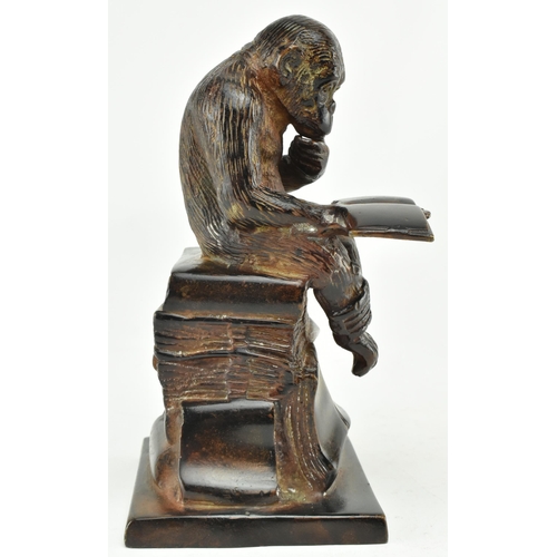 52 - A bronze figure depicting Darwin's reading monkey. The sculpture featuring a monkey reading a book i... 