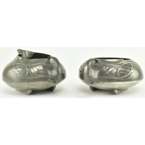 64 - An Art Nouveau early 20th century English pewter set comprising sugar bowl & cream jug. Each decorat... 