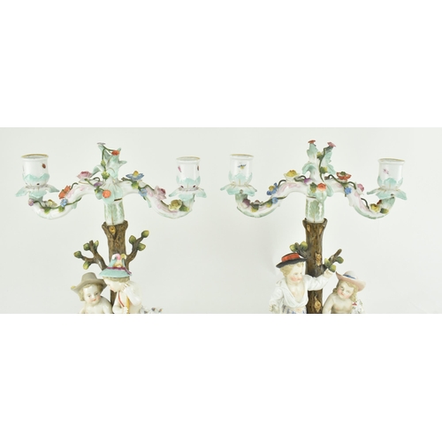 88 - A pair of German late 19th century Sitzendorf porcelain twin armed candelabra candlesticks. Each can... 