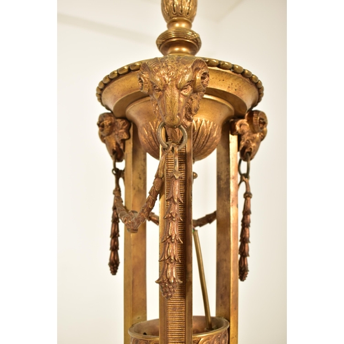 307 - A Neo-classical inspired brassed metal floor standard lamp. The lamp having three adjustable heads o... 