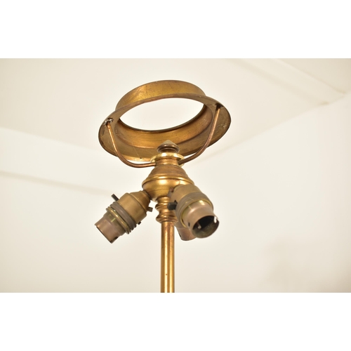 307 - A Neo-classical inspired brassed metal floor standard lamp. The lamp having three adjustable heads o... 