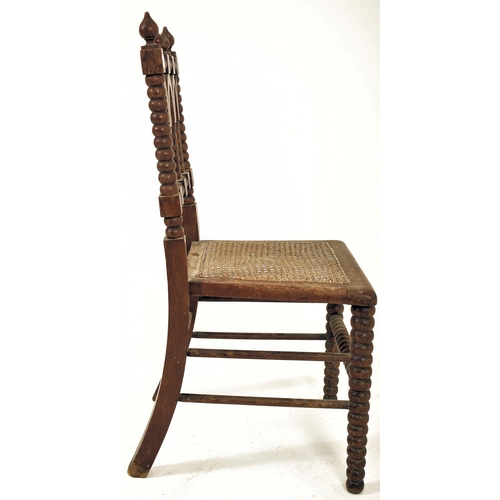 312 - An Arts & Crafts late 19th century Gothic inspired carved oak bobbin turned chair. The chair having ... 