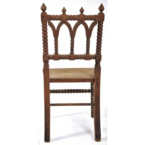 312 - An Arts & Crafts late 19th century Gothic inspired carved oak bobbin turned chair. The chair having ... 