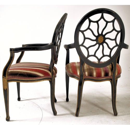 325 - A pair of Regency Revival ebonised & gilt painted spider web back armchairs. Each chair having a bal... 