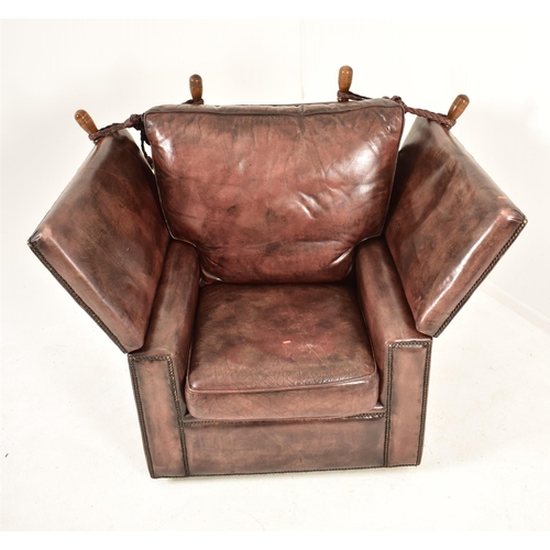 367 - A pair of Knole style brown leather drop-side armchairs. Each armchair having a straight back with w... 