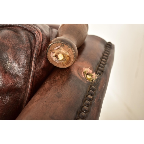 367 - A pair of Knole style brown leather drop-side armchairs. Each armchair having a straight back with w... 