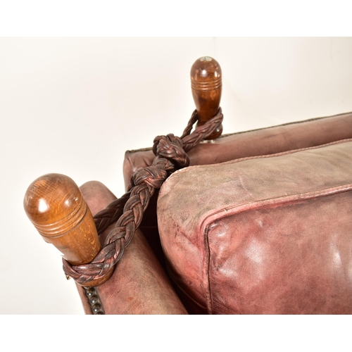 368 - A Knole style brown leather drop-side three seater sofa settee. The sofa having a straight back with... 