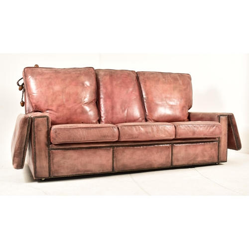 368 - A Knole style brown leather drop-side three seater sofa settee. The sofa having a straight back with... 