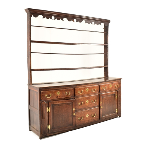 414 - A George III 18th century oak dresser. The dresser having an upright gallery plate rack  with flared... 