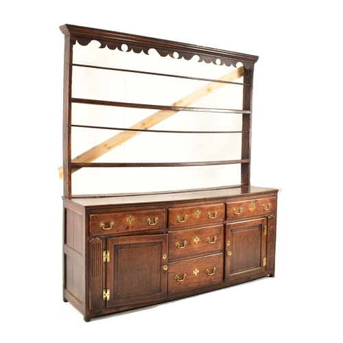 414 - A George III 18th century oak dresser. The dresser having an upright gallery plate rack  with flared... 