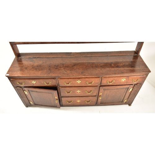 414 - A George III 18th century oak dresser. The dresser having an upright gallery plate rack  with flared... 