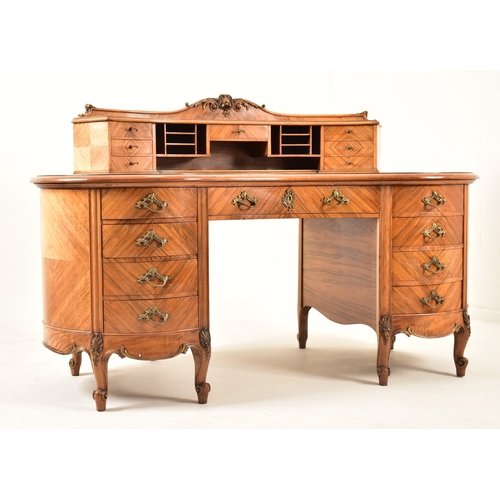 416 - A continental early 20th century walnut crossbanded twin pedestal kidney shaped desk. The desk havin... 