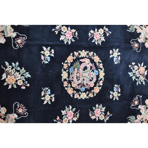 434 - A 20th century Chinese dragon carpet floor rug. With a black ground polychrome circular emblem with ... 