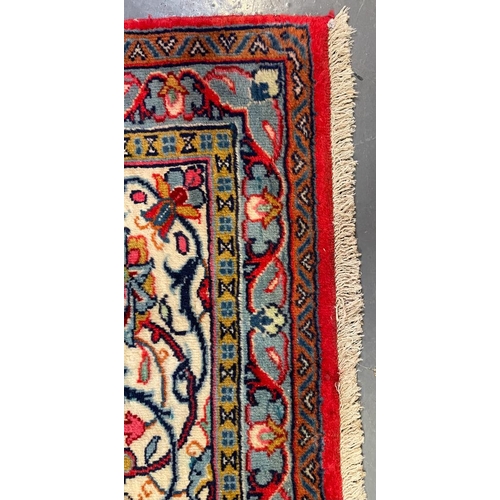 447 - A 20th century North West Persian Islamic Sarouk floor carpet rug. The rug having a central red pane... 