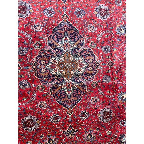 447 - A 20th century North West Persian Islamic Sarouk floor carpet rug. The rug having a central red pane... 