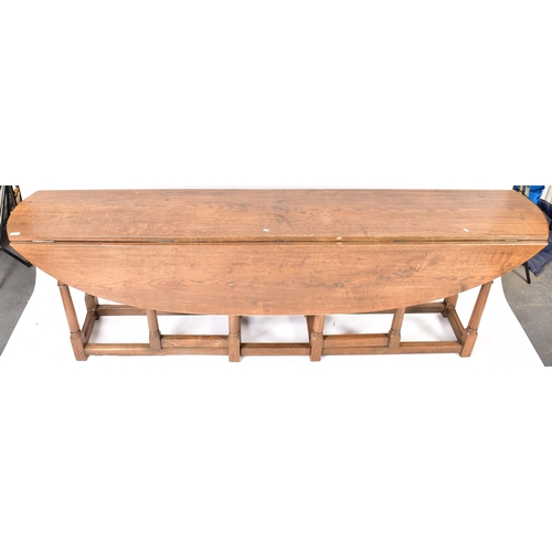 448 - An Irish manner large peg jointed solid oak wake dining table. The large table raised on block and t... 