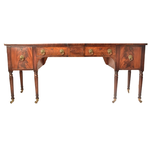 504 - A late 18th century George III mahogany credenza – sideboard. The credenza being raised on turned an... 