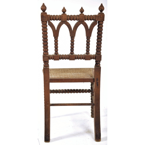 312 - An Arts & Crafts late 19th century Gothic inspired carved oak bobbin turned chair. The chair having ... 