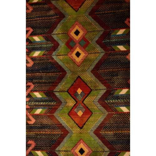 510 - A 20th century Afghan Islamic Kilim floor carpet rug. The rug having a central forest green panel wi... 