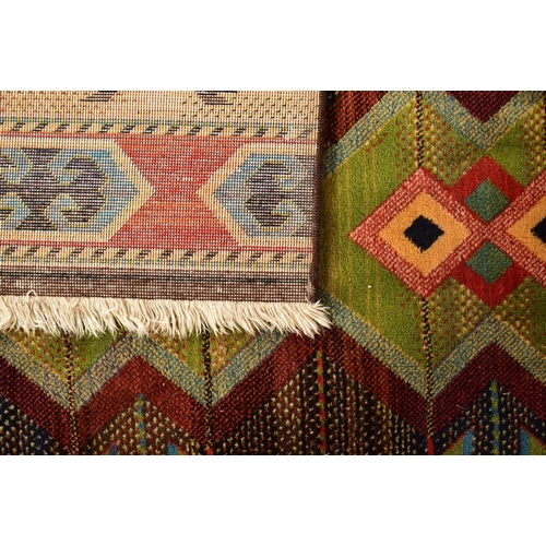 510 - A 20th century Afghan Islamic Kilim floor carpet rug. The rug having a central forest green panel wi... 