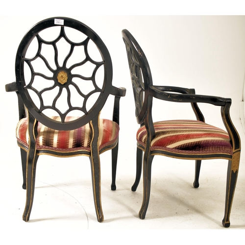 325 - A pair of Regency Revival ebonised & gilt painted spider web back armchairs. Each chair having a bal... 