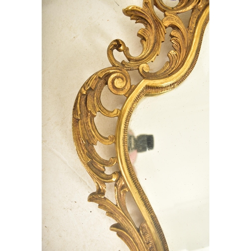 538 - A 19th century continental Baroque inspired gilt metal wall hanging mirror. The mirror having a cart... 