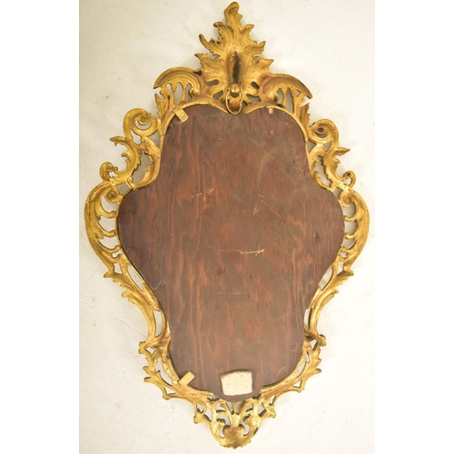 538 - A 19th century continental Baroque inspired gilt metal wall hanging mirror. The mirror having a cart... 