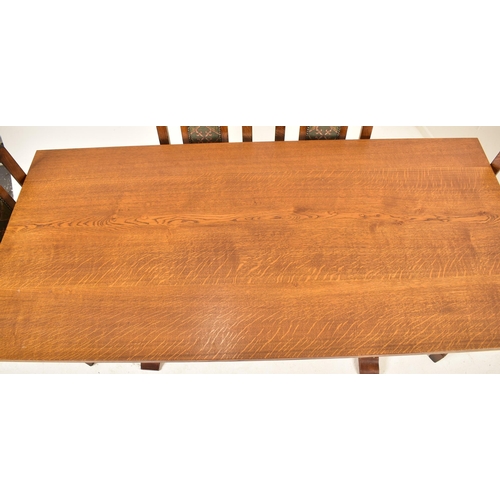 548 - A large 20th century solid oak refectory dining table and matching eight chairs. The table of rectan... 