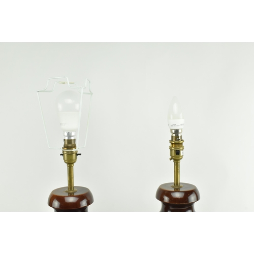 555 - A pair of turned wooden desk table lamps shades in the shape of urn in the manner of Porta Romana. E... 