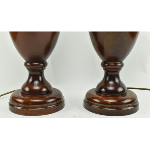 555 - A pair of turned wooden desk table lamps shades in the shape of urn in the manner of Porta Romana. E... 